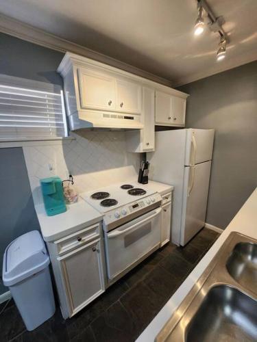 Blue Shark G9 - Midtown 1BR King Suite في هيوستن: مطبخ مع موقد وثلاجة