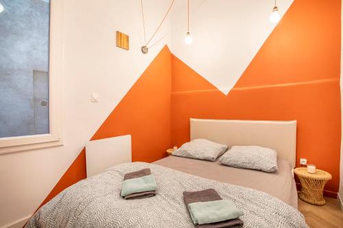 deux lits dans une chambre avec un mur orange dans l'établissement Charmant T2 centre, à Aix-en-Provence