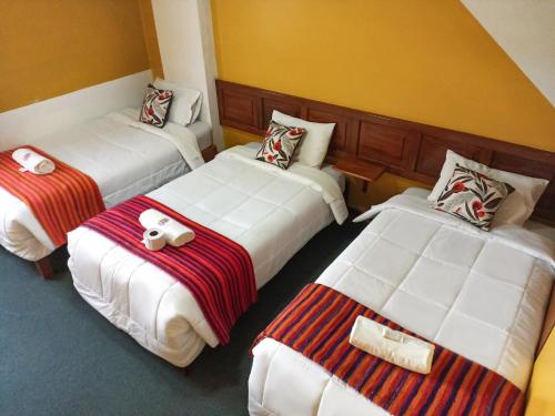una habitación de hotel con 2 camas en una habitación en Huaraz Center Hostal, en Huaraz