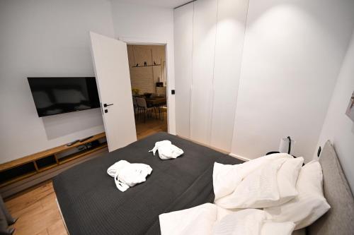 um quarto com duas toalhas brancas numa cama em Politika Square Bliss em Belgrado