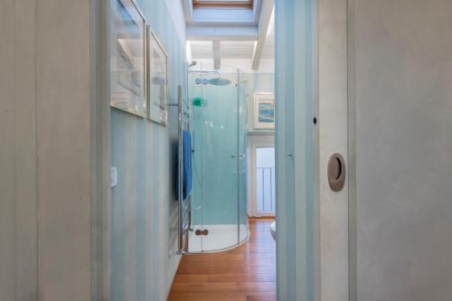 d'un couloir avec une salle de bains aux murs bleus et une porte en verre. dans l'établissement Fifty Eight Suite Milan Sforza, à Milan