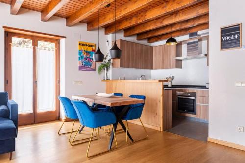 a kitchen with a wooden table and blue chairs at Refugio en las Cumbres in Las Bordas