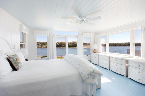 una camera da letto bianca con un letto grande e finestre di Sailor Sanctuary a Orleans