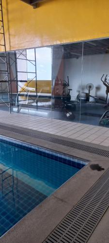 uma piscina com um reflexo no vidro em Staycation in Quezon City with Netflix and Pool access at Tranquil Space by Ada em Manila