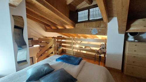 ein Schlafzimmer mit einem Bett mit blauen Kissen in der Unterkunft Loft della Perpetua di Casa Bernardi, romantica mansarda nelle Dolomiti di Brenta in Montagnaga
