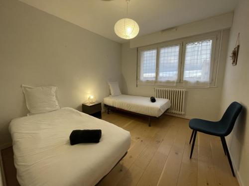 - une chambre avec 2 lits et une chaise dans l'établissement L'Olympe - Balcon - Centre - 4p - Rêve au Mans, au Mans