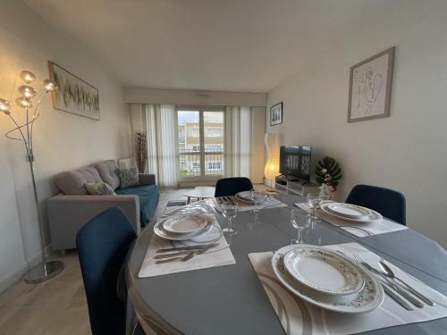une salle à manger avec une table avec des assiettes et des verres à vin dans l'établissement L'Olympe - Balcon - Centre - 4p - Rêve au Mans, au Mans