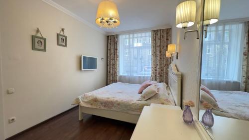 Dormitorio pequeño con cama y espejo en Apartment in the Centre of City, en Dnipro
