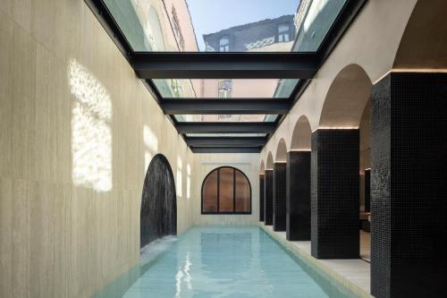 阿威羅的住宿－MS Collection Aveiro - Palacete Valdemouro，一座带玻璃天花板的建筑中的游泳池