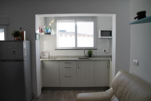 a kitchen with a sink and a window at Apartamentos Alazul Pleamar y Alazul Bajamar in Conil de la Frontera