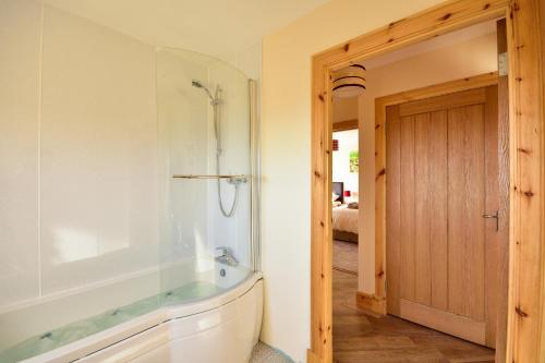a bathroom with a tub and a glass shower at Beachcombers in Pollachar