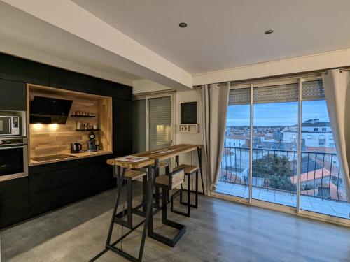 - une cuisine avec un bar offrant une vue dans l'établissement Hyper Centre La Roche sur Yon - Appartement spacieux et lumineux, à La Roche-sur-Yon