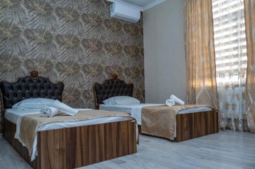 two twin beds in a room with a wall at Qafqaz Milan Villa With Outdoor Heated Pool in Gabala