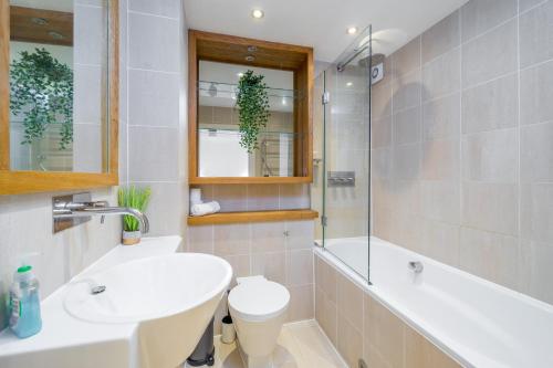 a bathroom with a sink and a tub and a toilet at Deluxe 2Bed Duplex Apartment & parking in London