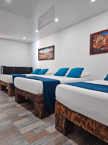 a row of four beds in a room at Hosteria La Medusa in Cocorná