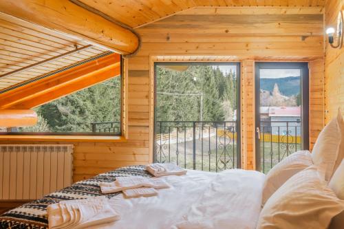 a bedroom with a bed and a large window at Chalet Ciocanesti in Ciocăneşti