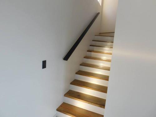 a staircase with white walls and wooden floors at Coral Views Resort - Villa uMaMi in French Harbour