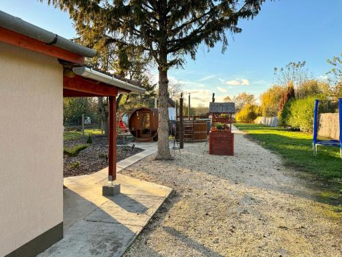 a park with a tree and a playground at Panka Üdülőház - Templom-zug in Gyomaendrőd