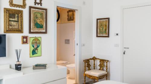 baño con aseo y pinturas en la pared en Villa Urbis Taormina, luxury villa in the heart of Taormina with swimming pool & lift, en Taormina