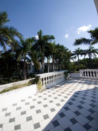 a patio with a white fence and palm trees at Casa Tzunun Airport Junior Suite in Cancún