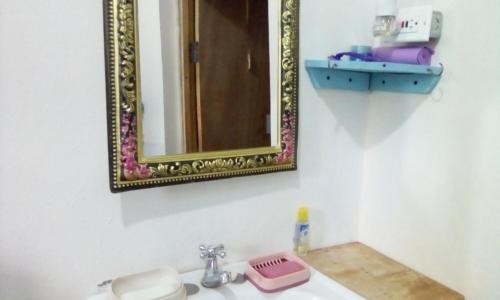a bathroom sink with a mirror and a pink scale at Relax N Sunshine 