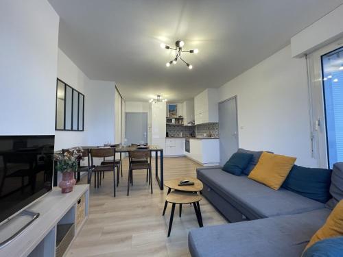 un salon avec un canapé et une salle à manger dans l'établissement Le Paradise - Centre - Balcon - 4p - Rêve au Mans, au Mans