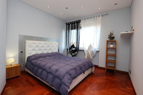 sypialnia z łóżkiem z fioletową narzutą w obiekcie Casa sotto le stelle w Turynie