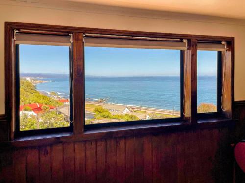 a window with a view of the ocean at Hotel Bután Coronel in Coronel