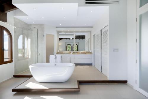 a bathroom with a large white tub and a sink at Fine 3 BR Oceanview Penthouse in Prime Location - La Perla Sky in Cupecoy