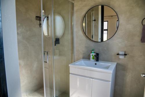 a bathroom with a sink and a mirror at Highland Gate Eagles Breeze in Dullstroom