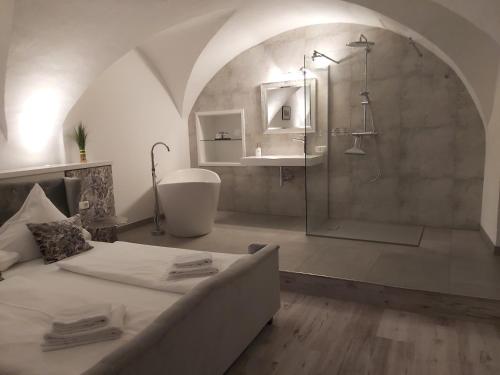 Gasthof Ginzinger في Mauerkirchen: حمام كبير مع سرير ودش