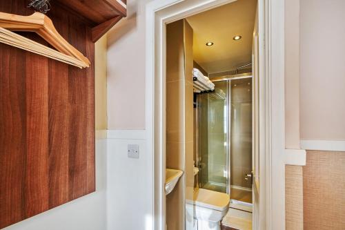 a bathroom with a shower and a walk in closet at Huttons Hotel, Victoria London in London
