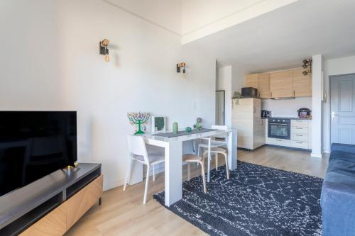 un salon avec une table et des chaises et une cuisine dans l'établissement Charmant T3 proche centre ville avec parking, à Aix-en-Provence
