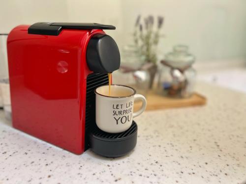 a coffee cup is being inserted into a toaster at Studio 118 - A luxury place,Self Check-in ,10 min from City Center in Timişoara