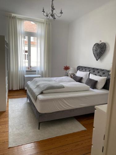 Un dormitorio con una cama grande y una ventana en Altbau-Oase der Eleganz: Stadtnaher Komfort pur, en Wiesbaden