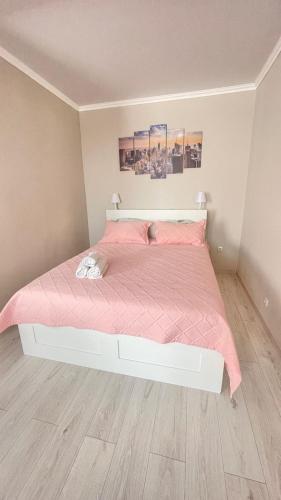 a bedroom with a bed with a pink comforter at # 50 Солнечная комфортная студия in Atyrau