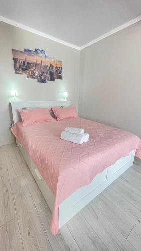 1 dormitorio con cama rosa y edredón rosado en # 50 Солнечная комфортная студия, en Atyraū