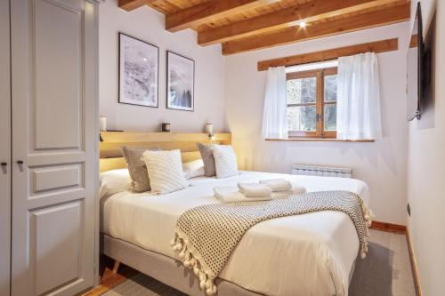 sypialnia z 2 łóżkami i oknem w obiekcie Luderna - Apartamento con jardín Pleta de Arties Montardo w mieście Arties