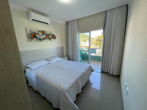 1 dormitorio con cama y ventana en Res Costa Verde, en Bombinhas
