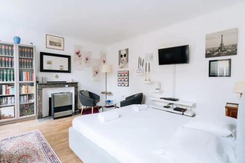 sala de estar con sofá blanco y chimenea en Cosy 1 Bedroom in the heart of Montparnasse, en París