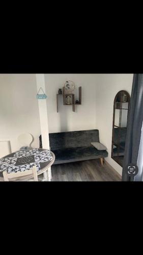 a room with a table and a bench and a shelf at Studio « Bâbord » Le Tréport - vue mer & falaises in Le Tréport
