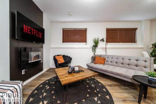a living room with a couch and a table at Chic Modern Vibes - KING Bed - Fireplace - Sleeps 4 - Wifi in Edmonton