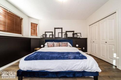 - une chambre dotée d'un grand lit avec des draps bleus et blancs dans l'établissement Chic Modern Vibes - KING Bed - Fireplace - Sleeps 4 - Wifi, à Edmonton