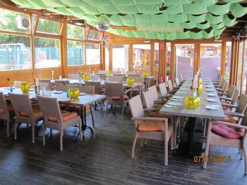 a dining room with tables and chairs and windows at Kastanienhof in Mönchengladbach
