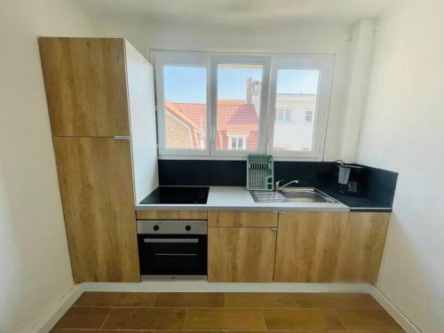a small kitchen with a sink and a window at Calme - Balcon - 2 à 4 pers - WIFI - plage à 100m in Berck-sur-Mer