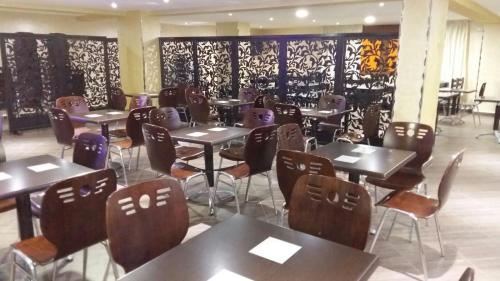 a restaurant with tables and chairs in a room at Hôtel Marina in Tetouan