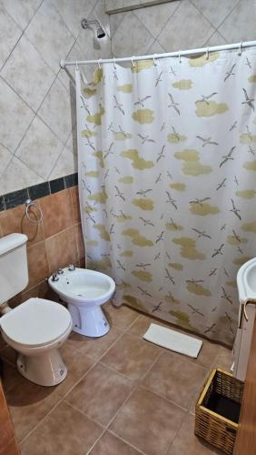a bathroom with a toilet and a shower curtain with fish at KILKA's in Caviahue