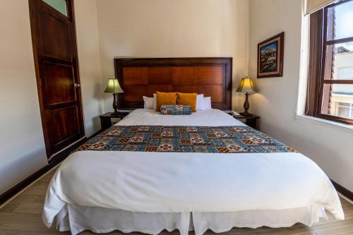 a bedroom with a large white bed with two lamps at Hotel Cuenca in Cuenca
