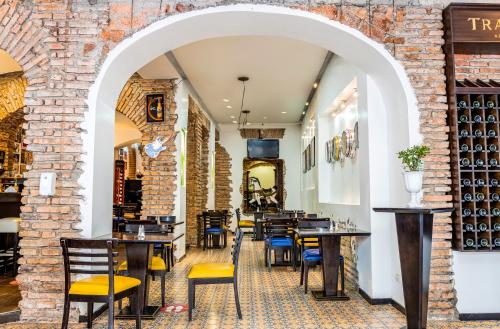 a restaurant with tables and chairs and a brick wall at Hotel Cuenca in Cuenca