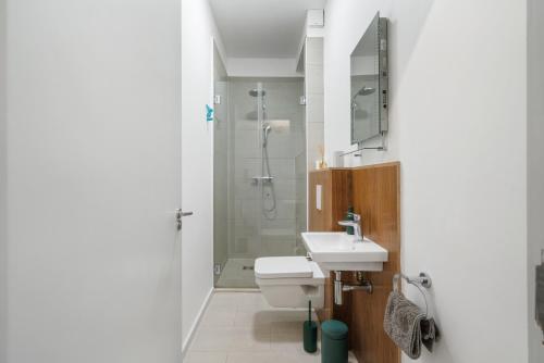 a bathroom with a shower and a toilet and a sink at Ickburgh Road Guesthouse in London